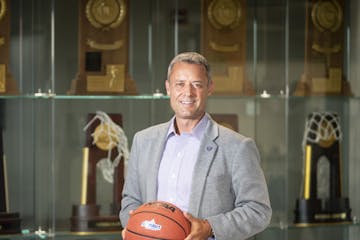 Athletic Director Phil Esten stood for a photo in front of the trophy case at the University of St. Thomas