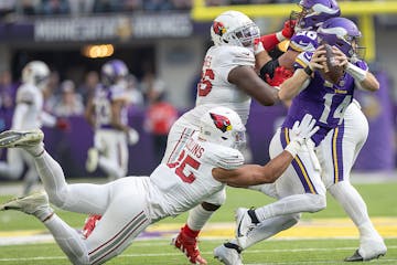 Vikings quarterback Sam Darnold slips away from Cardinals linebacker Zaven Collins in the second quarter Sunday.