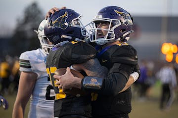 Minnesota State Mankato quarterback Hayden Ekern, right, hugs running back Christian Vasser after taking the final snap to defeat Bemidji State 27-23